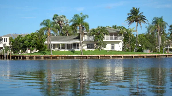 Typical luxury vacation summer home exterior establishing shot photo during day time. Generic large expensive real estate mansion along coastal waterway river