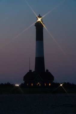 Fire Island fener feneri ışığı gece vakti Robert Moses plajında parlayan fener ışığından açık sularda seyahat eden okyanus teknelerine işaret veriyor.