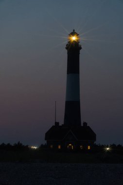 Fire Island fener feneri, gece vakti Robert Moses plajında parlayan fener ışığından açık denizde seyahat eden okyanus teknelerine işaret eden muhteşem hiper yıldız efekti.