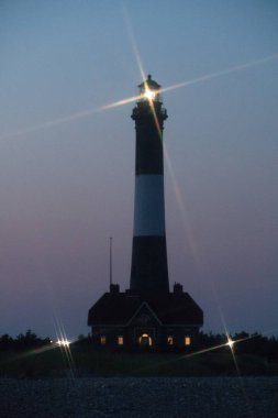 Fire Island fener feneri ışığı gece vakti Robert Moses plajında parlayan fener ışığından açık sularda seyahat eden okyanus teknelerine işaret veriyor.