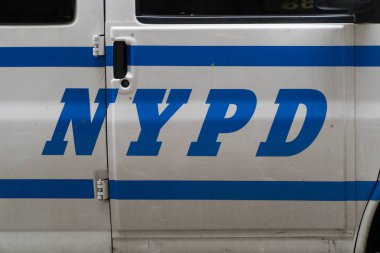 New York City, Circa 2019: New York Polis Departmanı logo mektupları gün içinde Manhattan yolunda park halindeki polis aracının kapısına yazıldı