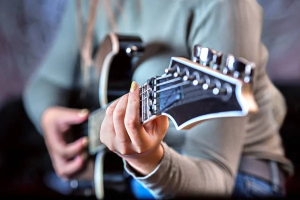 Close-up of female hands holding electric guitar — Stock Photo, Image