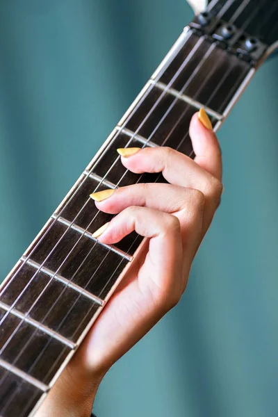 Närbild av kvinnlig hand som innehar elgitarr — Stockfoto