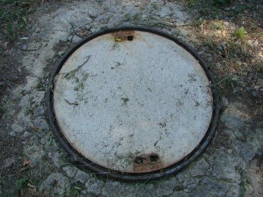 Demir kanalizasyon kapağı ya da bir caddeye dere kapağı atın.