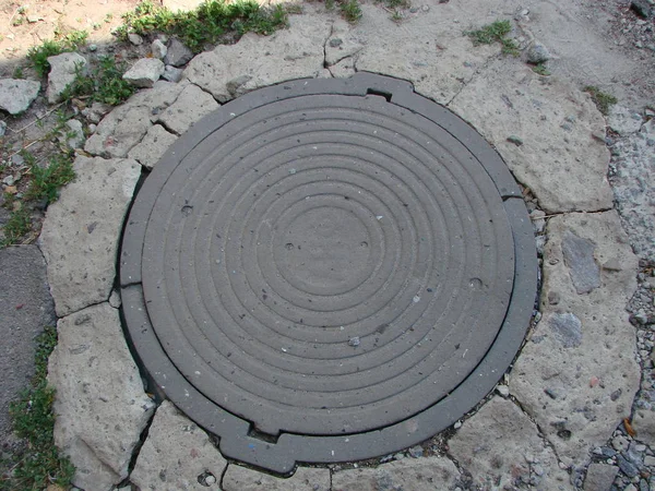 Cast iron manhole cover or gully cover on a street — Stock Photo, Image