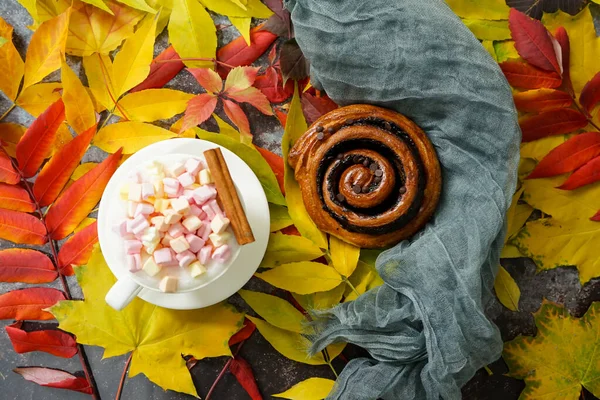 Осенние сушеные листья с блокнотом, шоколадной булочкой и зефиром — стоковое фото