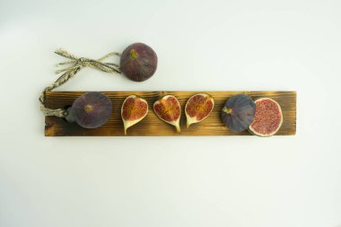 Tahta üzerinde beyaz arka planı olan taze, lezzetli incirler. Metin için alanı olan pankart.