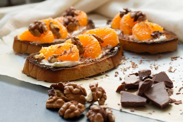 Siyah ahşap arka planda tatlı mandalina ve krem peynirli lezzetli tost. Boşluğu kopyala.