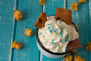 Kahve, sütlü ve kurabiyeli milkshake. Patlamış mısırlı mavi ahşap bir arka planda