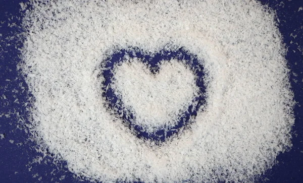 Heart on artificial snow. Blue background. Valentine\'s day. Feelings and emotions. Love. Installation.