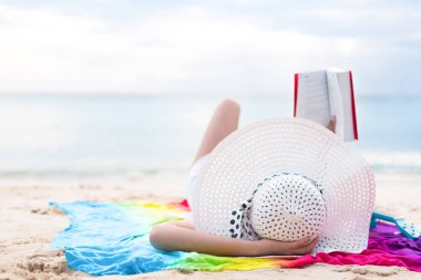 Banyo ve okuma Asyalı kadın güneş tatil beach adlı kitap. Güzellik ve Doğa Tema. Okyanus ve deniz arka plan. Kadın gün ve gevşeme Tema