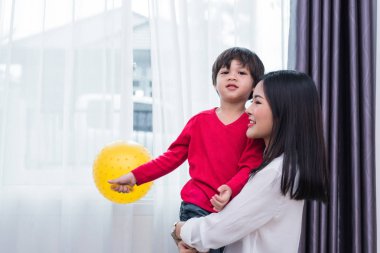 Anne, oğluna sarılıp, oğlunu taşısın. Sabah çocuklarını okula geri göndermeye hazırlanıyor. Eğitim ve Okula Dönüş kavramı. Mutlu aile ve sevgi dolu insanlar teması