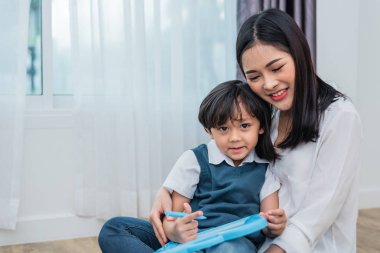 Asyalı anne birlikte tebeşir tahtası çizim sevimli çocuk öğretiyor. Okula ve eğitim anlayışına geri dönelim. Aile ve Ev tatlı ev teması. Okul öncesi çocuklar teması.