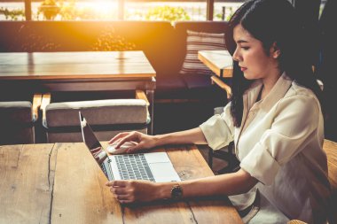 Kafede dizüstü bilgisayar ile çalışan Asyalı kadın. İnsanlar ve yaşam kavramı. Açık havada çalışan ve serbest Tema.
