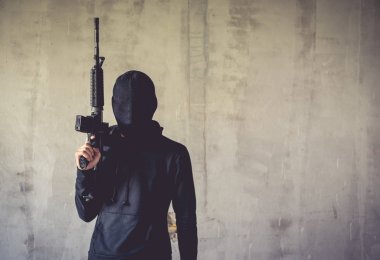 Elinde tüfeği silah grunge duvarda bir terörist. Sosyal verilen tema. Terörist ve soyguncu kavramı. Polis ve asker tema. Sosyal verilen Tema.