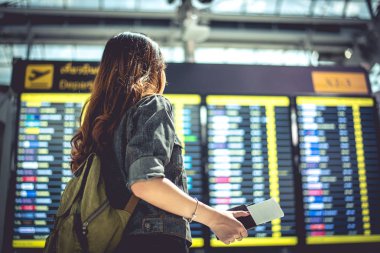 Güzellik kadın turist kontrol etmek için uçuş tarifeleri bakarak zaman alır. İnsanlar ve yaşam kavramı. Tek kadın tema seyahat ve mutlu hayat. Arkadan görünüm portre.