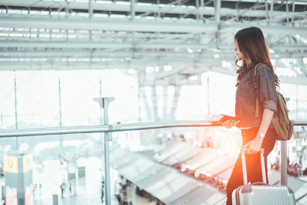 Beauty woman waiting for take off flight in airport. Asian woman with trolley suitcase. People and lifestyles concept. Transportation and Travel theme. Airplane and train theme. 