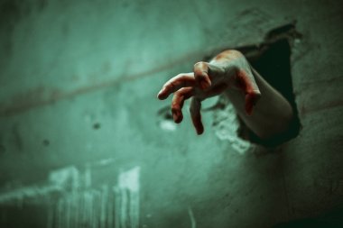 Zombi el kırık duvarda. Korku ve korku filmi kavramı. Cadılar Bayramı Günü teması. Hayalet film gibi yeşil tonu