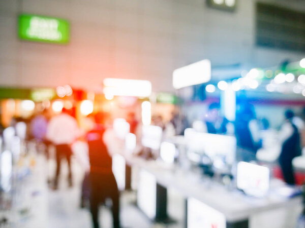 Blurry background of exhibition expo with crowd people in convention hall.