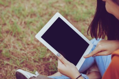 Güzellik Asyalı kadın Parkı'nda tablet kullanma. İnsan ve teknoloji kavramı. Eğlence ve Outdoor aktivite Tema.