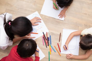 Okul öncesi öğrenci ve öğretmen sanat sınıfında kağıt üzerinde çizim grubu. Okula ve eğitim anlayışına geri dönelim. İnsanlar ve yaşam tarzları teması. kreşte sınıf