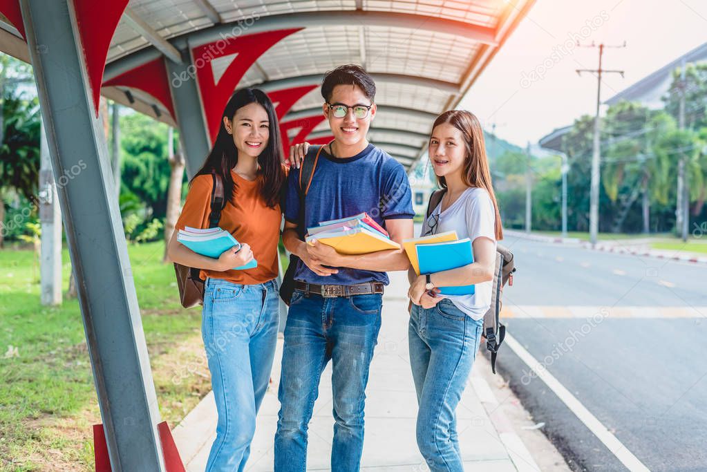 Three Asian young campus students enjoy tutoring and reading books together. Friendship and Education concept. Campus school and university theme. Happiness and funny of learning in college