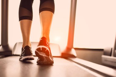 Eşofman ve spor ayakkabı koşu bandı koşu kadın bacak kapatın. Spor ve egzersiz kavramı. İnsanlar ve eğlence kavramı. Sağlık ve yaşam tarzı tema. Arkadan görünüşü alt beden. Sıcak sesi