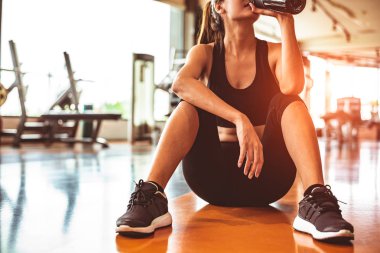 Spor egzersiz yaptıktan sonra dinlenme rahatlayın veya fitness salonunda egzersiz. Oturma ve katta protein sallamak ya da içme suyu içme. Vücut geliştirme ve vücut geliştirmeci kas tema. Sıcak ve soğuk sesi 