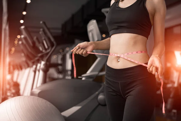 Sportif kadın fitness spor salonu spor kulübü Eğitim Merkezi kat mülkiyeti arka plan ile pencere yakınındaki bel bandı satırını kullanarak. İnsanlar egzersiz egzersiz spor etkinliği bir yaşam tarzı. Diyet ve kilo kaybı Tema.