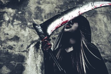 Reaper kan yalama cadı. Siyah giysiler ve grunge duvar arka plan kaputa dişi şeytan melek. Cadılar Bayramı gün ve gizem kavramı. Sihirli Tema fantezi. Ölümden sonra yaşam ve ölüm kavramı.