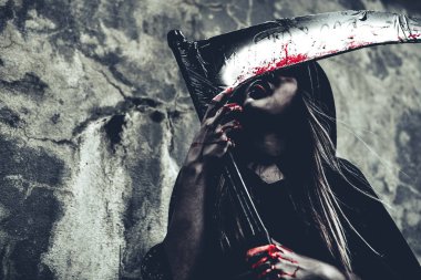 Reaper kan yalama cadı. Siyah giysiler ve grunge duvar arka plan kaputa dişi şeytan melek. Cadılar Bayramı gün ve gizem kavramı. Sihirli Tema fantezi. Ölümden sonra yaşam ve ölüm kavramı.