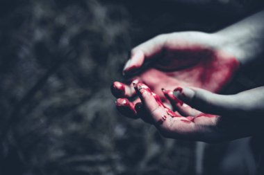 Kanlı eller karanlık ormanın arka planda kapatın. Korku ve ruh kavramı. Kavramı, suç ve cinayet. Cadılar Bayramı gün ve kurban tema. İnsan ve din tema. Elinde avuç açın.