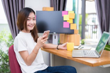 Asyalı kadın kendini dizüstü bilgisayar ve ofis telefon internet kullanırken zevk. İş ve pazarlama ve yarı zamanlı bir kavram. Online alışveriş ve iş başarı tema. Çalışma işi mutlu ruh hali.