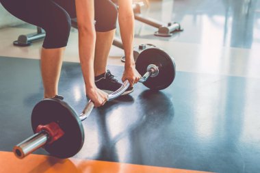 Spor salonunda ağırlık kaldıran spor kadınının yakın çekim. Egzersiz 