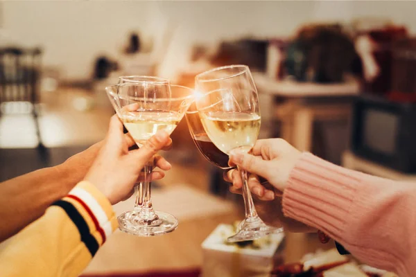 Hands of people celebrating New year party in home with wine dri