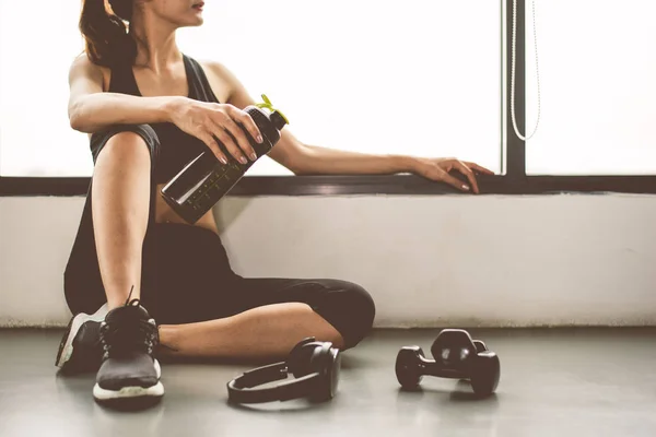 Mujer con mancuerna y dispositivo ejercicio estilo de vida entrenamiento en el gimnasio —  Fotos de Stock