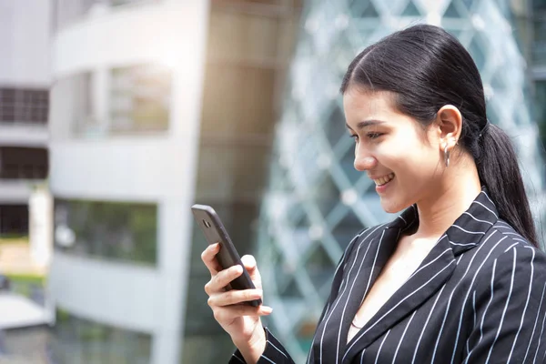 Happy beauty Asian woman looking at smart phone while smiling in — Stock Photo, Image