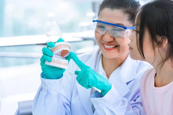 Little girl learning how brushing her teeth with female dentist — Stock Photo, Image