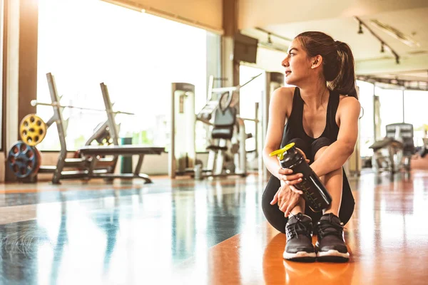 Спортивная женщина расслабиться после тренировки или физических упражнений в фитнес г — стоковое фото