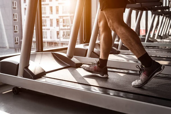 Jambes D'homme Avec Des Chaussures De Sport S'exécutant Sur Un Tapis  Roulant Dans Une Salle De Fitness.