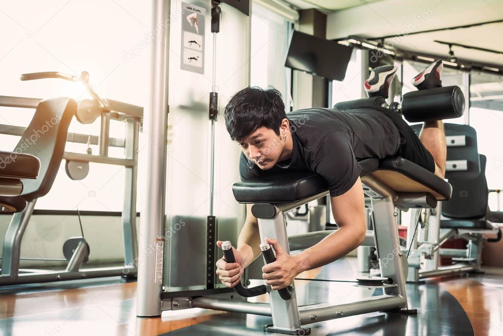 Asian sport man stretching and lifting weight by two legs when f