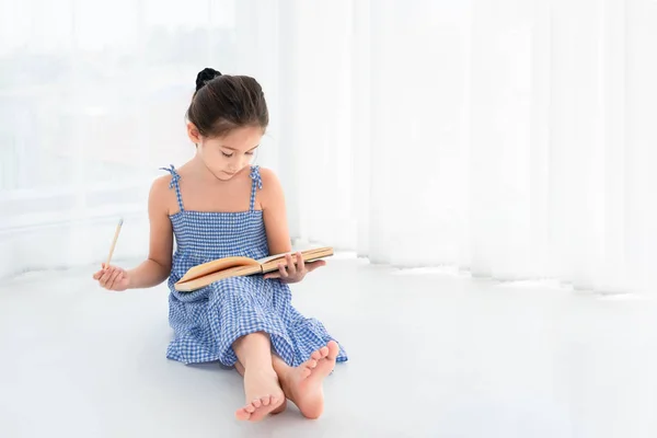 Urocza dziewczyna przegląda pracę domową i lekcje z notebookiem i Wooda — Zdjęcie stockowe