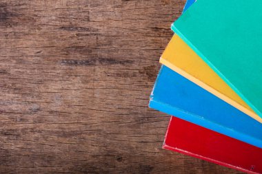 Ahşap masa üzerinde istifleme kitapları üst görünümü. Eğitim ve nesne