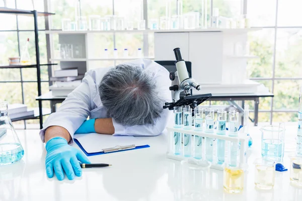 Exhausted scientist sleeping in laboratory. People lifestyles an — Stock Photo, Image