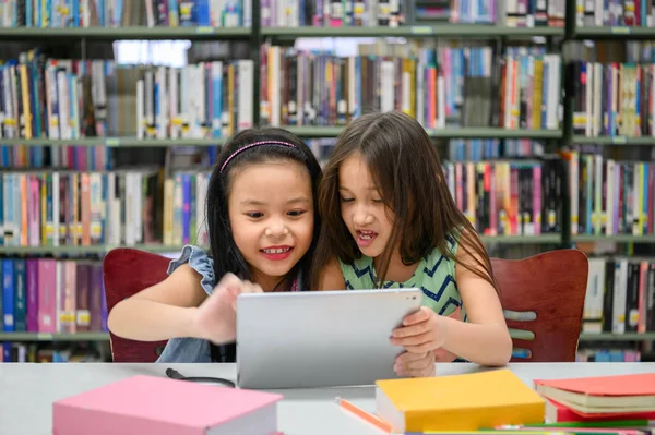 สาวน่ารักสองคนมีความสุข เล่นบนแท็บเล็ต คอมพิวเตอร์ dev — ภาพถ่ายสต็อก