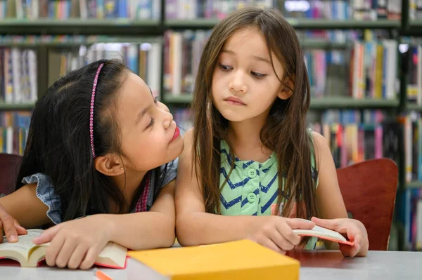 Duas meninas bonitos estão com ciúmes um do outro enquanto lendo livros em — Fotografia de Stock
