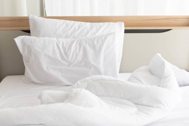 Beyaz perde ile güneşli sabah beyaz yapılmamış yatak