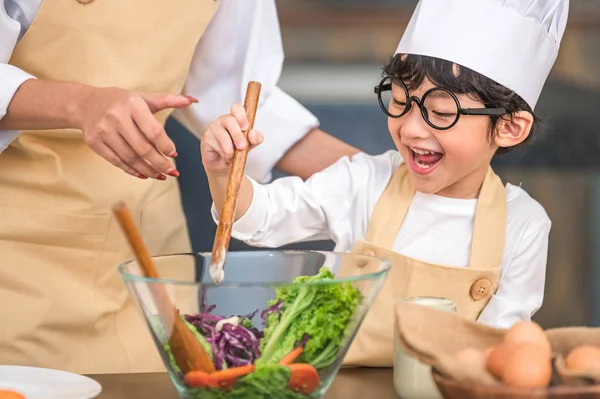 Lindo poco asiático feliz chico interesado en cocinar con madre fu — Foto de Stock