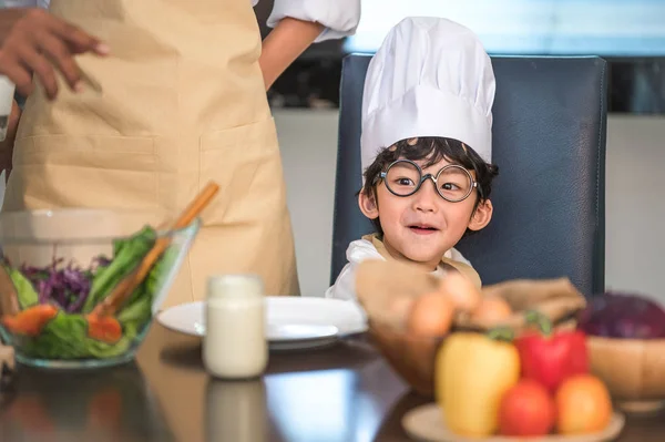 Primer plano de niño lindo asiático con sombrero de chef y delantal con — Foto de Stock