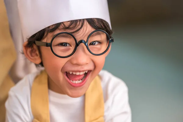 Retrato lindo pequeño asiático feliz chico interesado en cocinar con — Foto de Stock